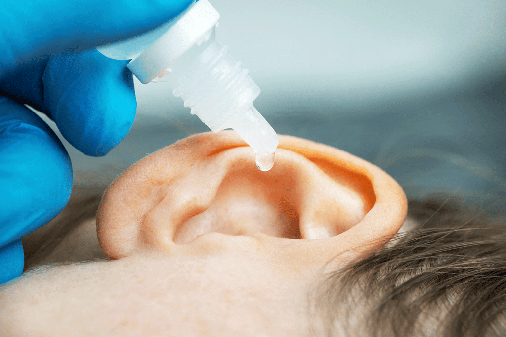 Child cleaning ears with peroxide